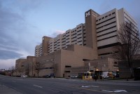 An outside view of the University of Michigan Hospital, a tan building with a large M on the outside