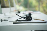 A photo of a call center employee's headset resting on a desk.