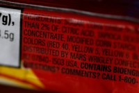 A photo zoomed in close-up on an ingredients list. The focus is on a list of food dyes.