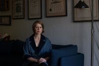 A photo of a woman sitting in her home.