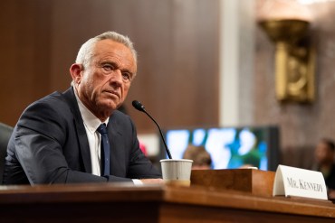 A photo of Robert F. Kennedy Jr. at his confirmation hearing in a Senate hearing room.
