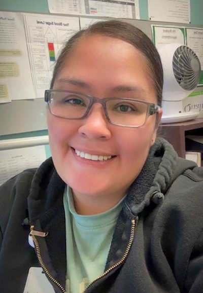 A close-up photo of a woman wearing glasses with her hair pulled back