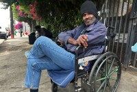 A portrait of a man sitting in a wheelchair outside.